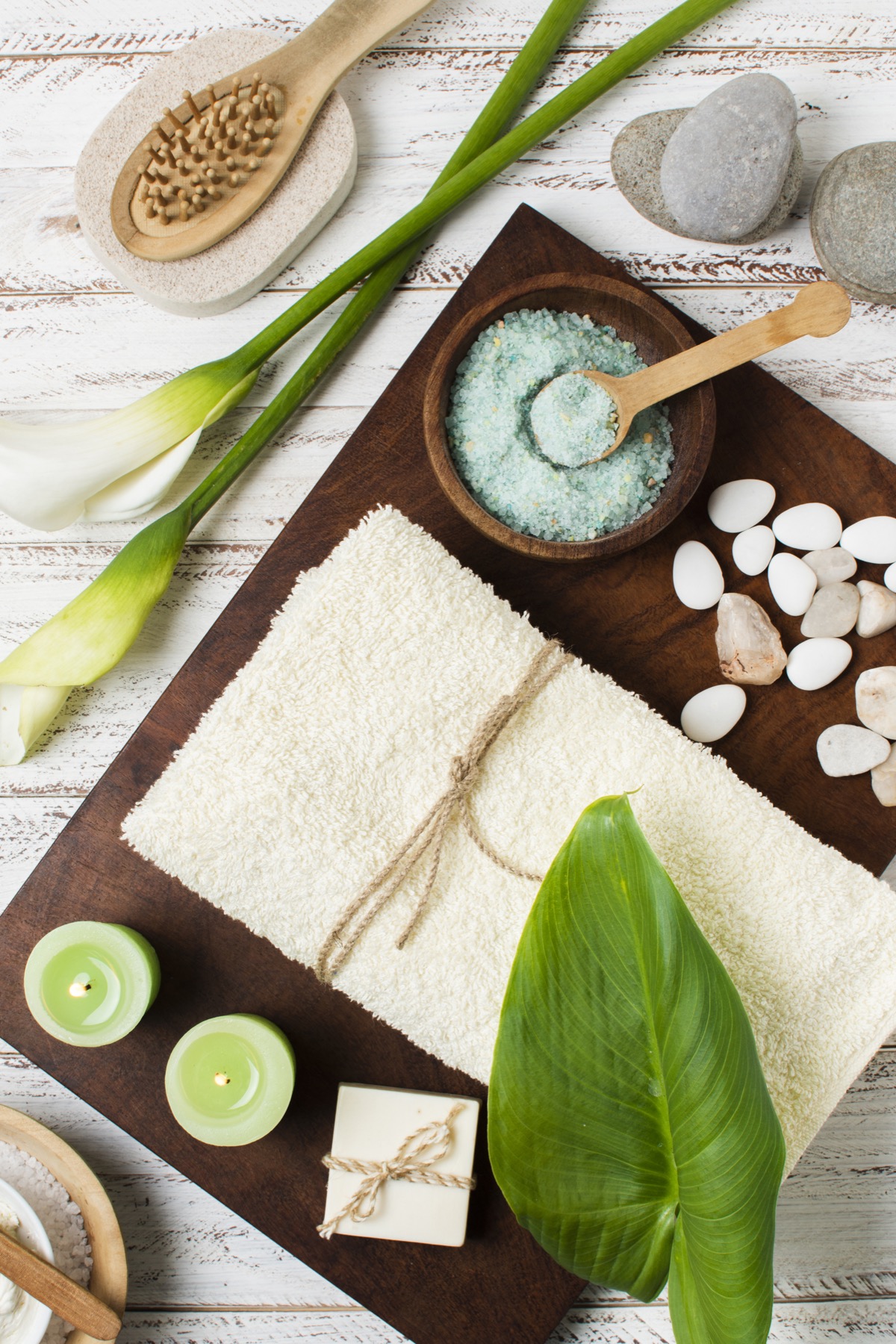 Composición de spa con sales, toalla, hojas, piedras y velas